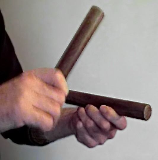 Two hands holding wooden claves ready to strike